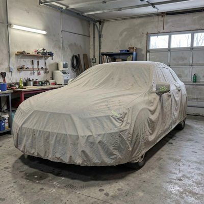 a car covered by a dust sheet in a garage