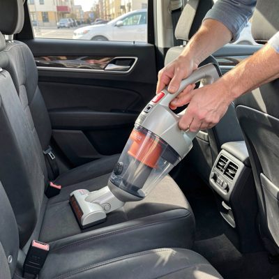 a car interior vacuum being used between seats