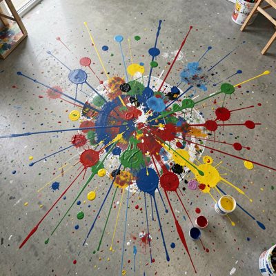 a paint splattered studio floor photographed from above