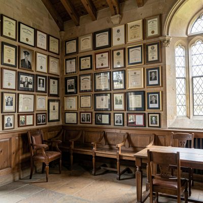 historic university hall adorned with framed diplomas and photos