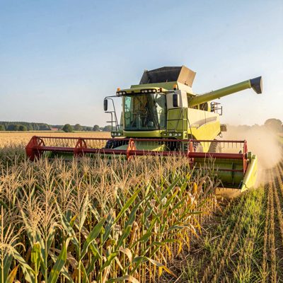 a combine harvester cutting through a crop