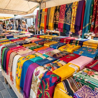 a market stall of scarves in bright colours