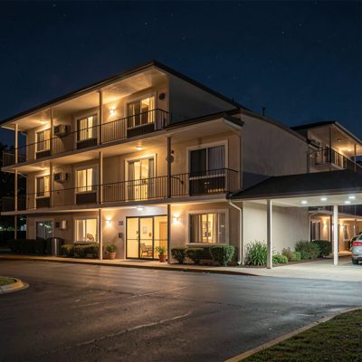 a motel exterior at night with room lights on