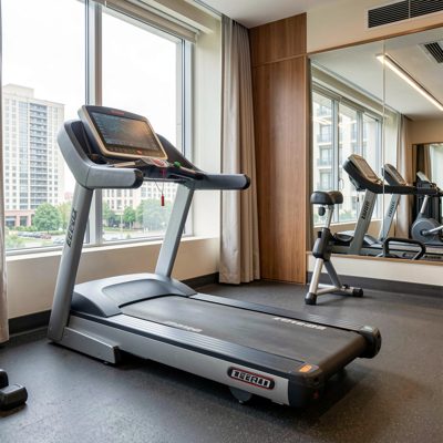 a hotel gym with a treadmill facing a window