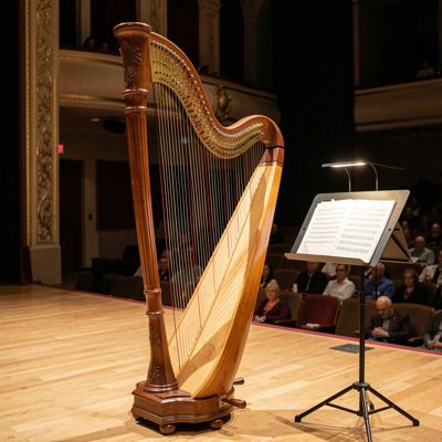 a harp on a stage beside sheet music