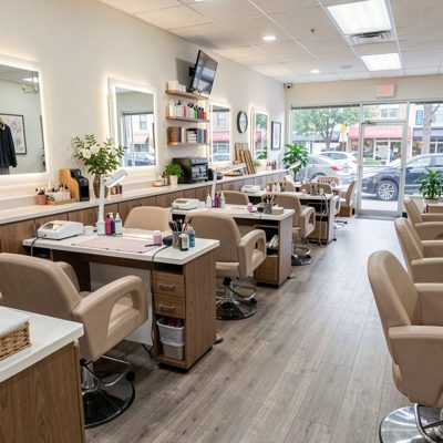 a nail salon interior with a row of manicure stations