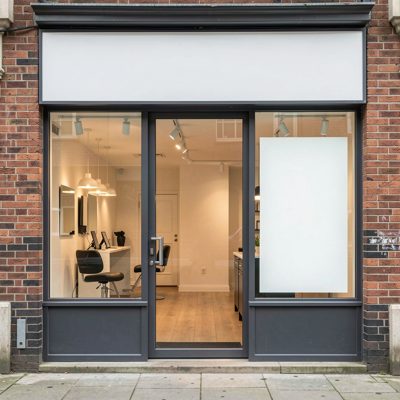 a salon shopfront with a blank sign and clean glass, blank empty sign board, no text, no lettering, no logo