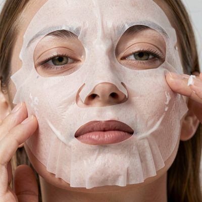 a sheet mask being smoothed onto skin