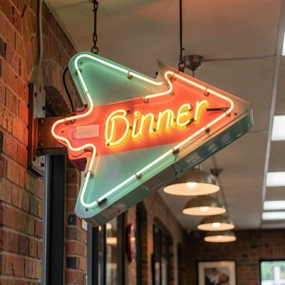 a diner sign shaped like an arrow