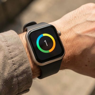 a smartwatch with a square face on a wrist showing a fitness ring